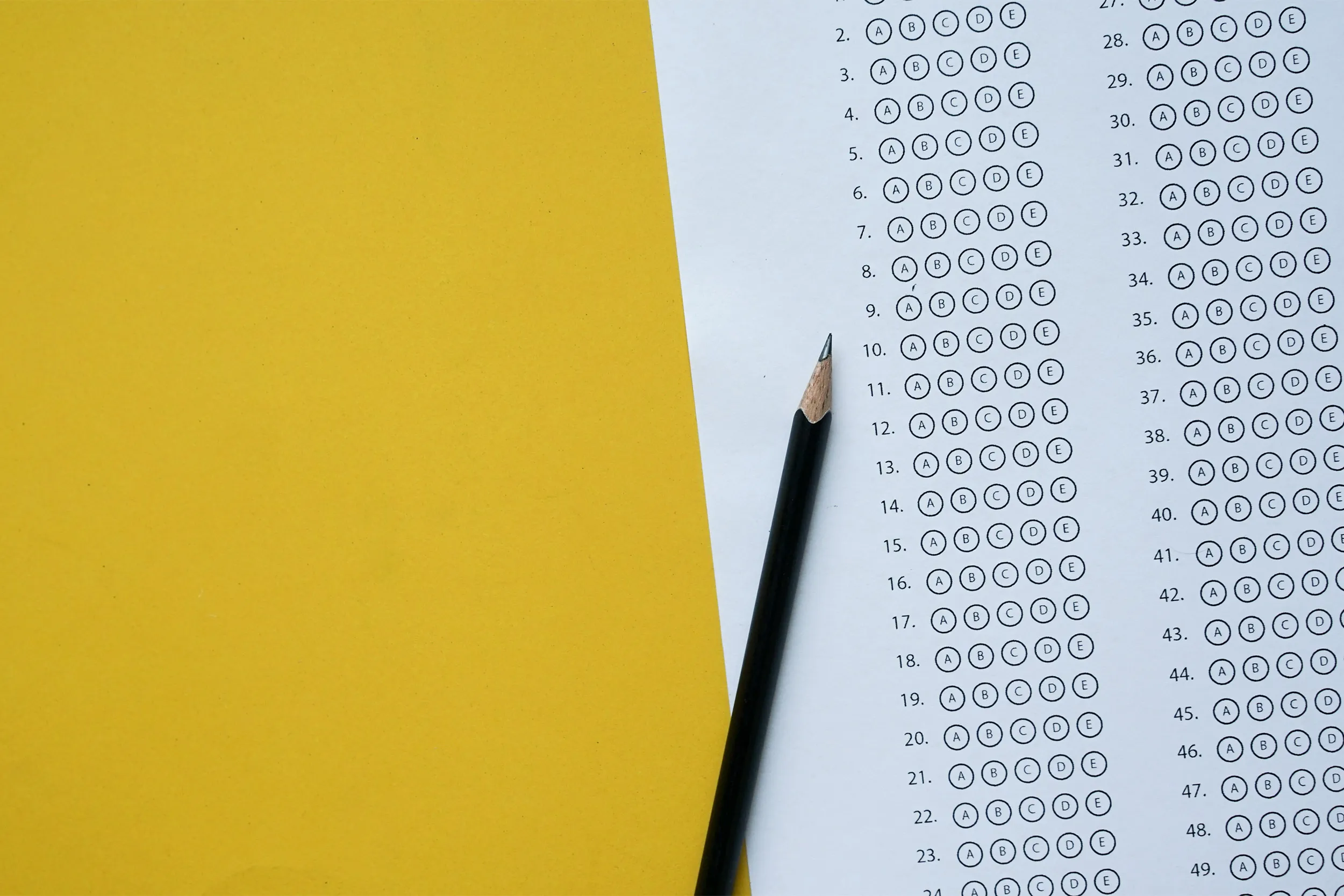 picture of standardized test bubble answer page with a pencil on a gray table